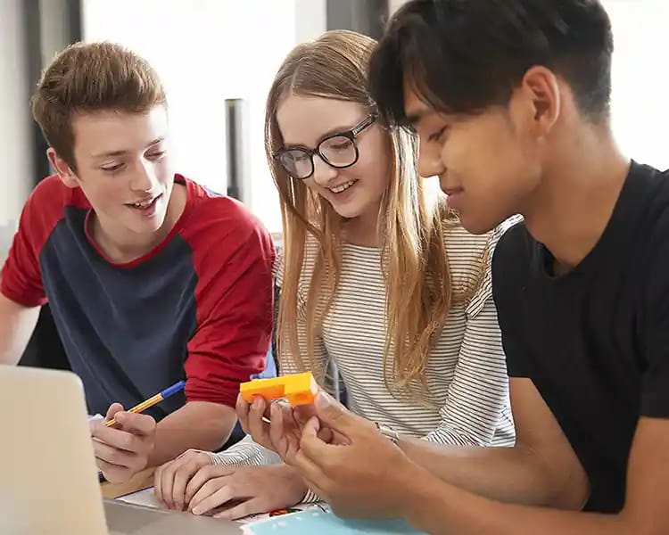 Adolescents réunis autour d’un ordinateur pour un projet scolaire